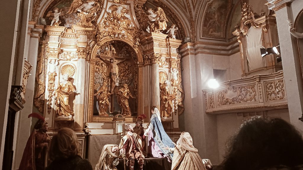 Rappresentazione storica in costume d'epoca davanti all'altare dorato barocco dell'Oratorio del Crocifisso a Foligno, vista dal pubblico