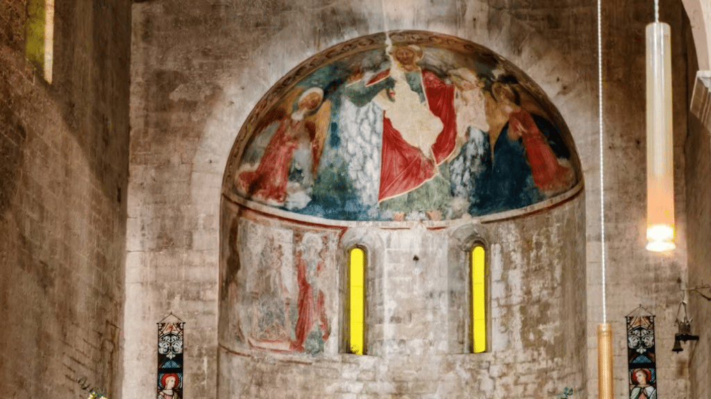 Particolare dell'affresco nel catino absidale dell'Abbazia dei Santi Felice e Mauro con figura sacra centrale tra angeli e monofore