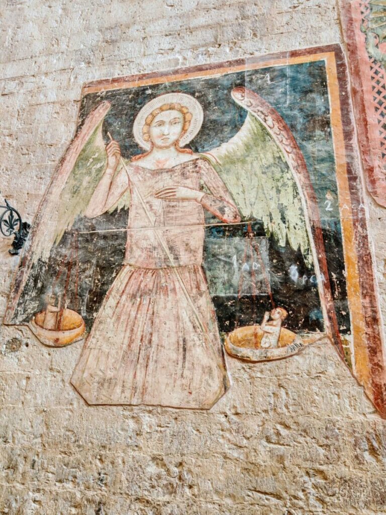 Antico affresco murale raffigurante l'Arcangelo Michele alato mentre regge la bilancia per la pesatura delle anime