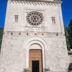Facciata in pietra calcarea dell'Abbazia dei Santi Felice e Mauro a Castel San Felice, con portale d'ingresso, rosone istoriato e bassorilievo romanico