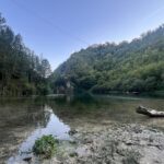 Riva alberata del Lago di Vigi a Sellano con alberi dorati riflessi nelle acque calm